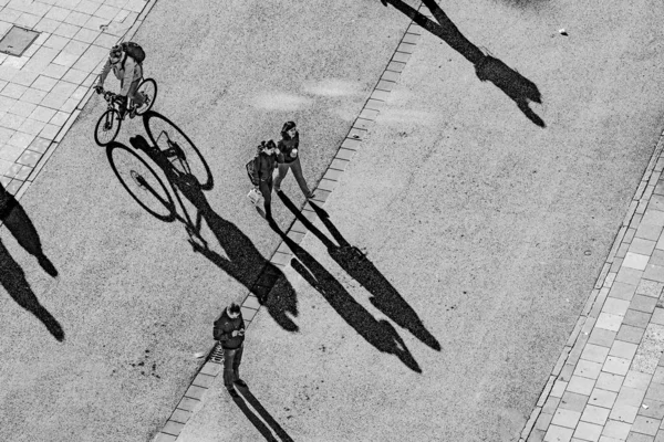 Menschen gehen mit langen Schatten auf der Straße — Stockfoto