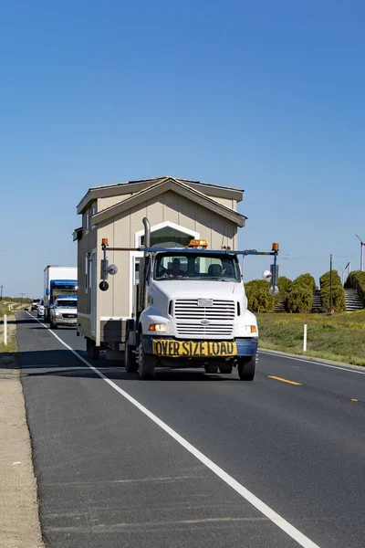 Ludzie transportują swój dom ciężarówką z jednej mobilnej willi domowej — Zdjęcie stockowe