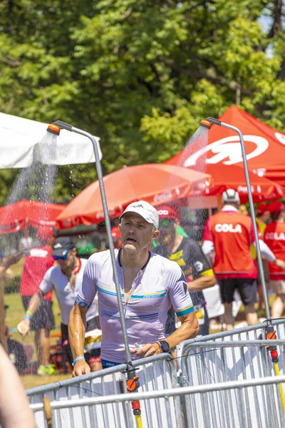 Athletes drink mineral water or get a shower while running at th — Stock Photo, Image