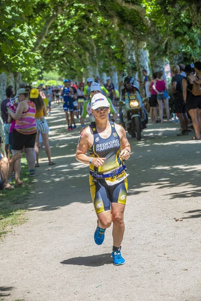 La atleta Jill Fullen corre un camino alternativo sombreado por árboles —  Fotos de Stock