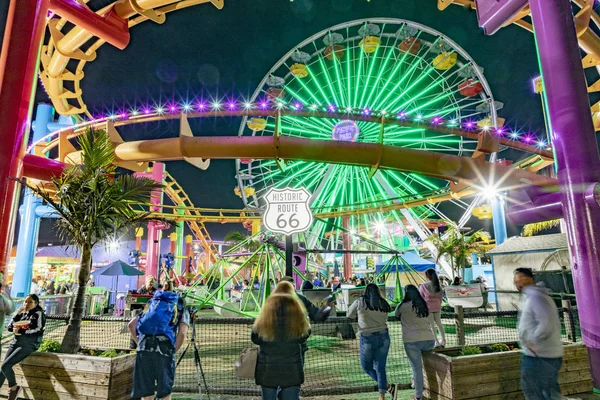 La gente disfruta del parque oceánico en el muelle de Santa Mónica por la noche —  Fotos de Stock