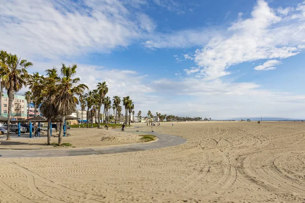 People enjoy scenic beach promenade with palms and colorful hous — Stock Photo, Image