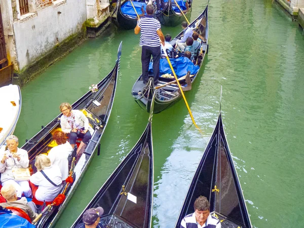 Människor njuta av att besöka kanalerna i Venedig med gondol — Stockfoto