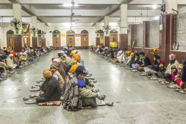 İnsanlar Harimandir Sahib 'in yiyecek bölümünde yemek bekliyor., 