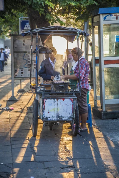 Woman at a portable snack car offers fresh grilled chicken stick — Stockfoto
