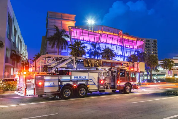 Fire rescue truck by night in front of a new art deco building w — Stock Photo, Image