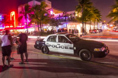 Polis arabası Ocean Drive 'a park ediyor Güney Sahili boyunca Miami' de