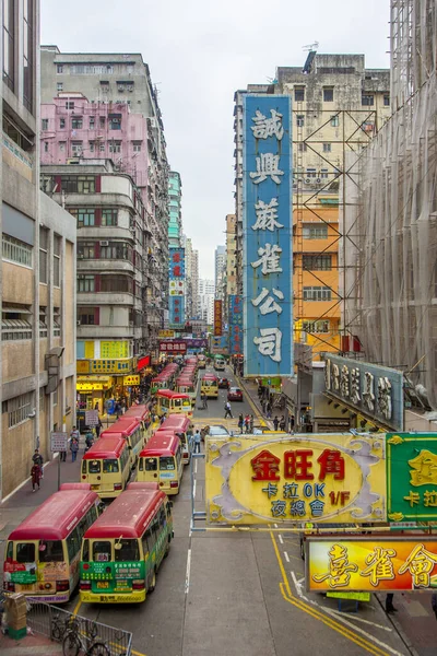 View to a shopping street in downtown Kowloon. Red busses wait f — Stockfoto