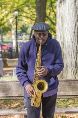 Adam New York 'taki Central Park' ta saksafon çalıyor.