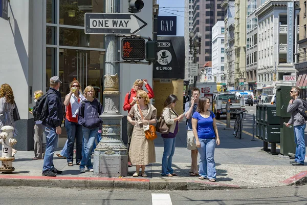 People wait at a pedestrian crossing for green light to cross th — Stock Photo, Image