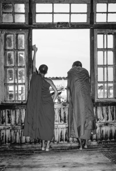 Manastırdaki iki keşiş Inle Gölü pencereden bakmak — Stok fotoğraf