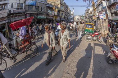 İnsanlar Ch 'deki eski Delhi pazarında küçük bir sokak boyunca yürüyorlar.