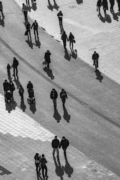 Mensen lopen in de straat met lange schaduwen — Stockfoto