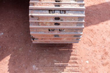 Kırmızı yeryüzündeki bir ekskavatör zinciri ayrıntılı olarak.