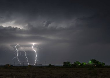 A large lightning strike at night in a rural area of Roswell, New Mexico framed against stormy skies. clipart