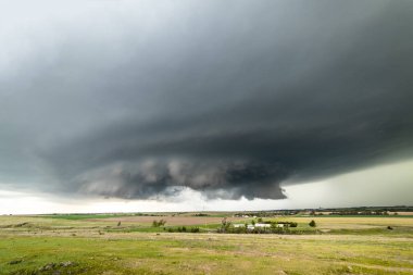 Large, powerful tornadic supercell storm moving over a small town in Oklahoma sets the stage for the formation of tornados across Tornado Alley. clipart