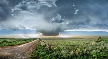 Panoramic image of a large, powerful tornadic supercell storm moving over the Great Plains during sunset, setting the stage for the formation of tornados across Tornado Alley. clipart