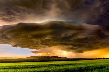 Panorama of a massive mesocyclone weather supercell, which is a pre-tornado stage, passes over a grassy part of the Great Plains while fiercely trying to form a tornado clipart