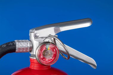 A classic red fire extinguisher valve on a blue background for use as a design element or safety inference for home and business protection clipart
