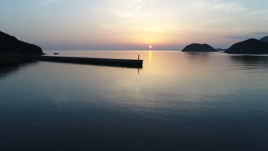 önceden uçan uçak, dalgakıran taş günbatımı denizin üzerinden havadan görünümü 