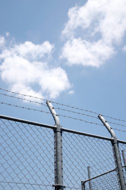 mavi gökyüzünde bir arka plan üzerine dikenli tel kafes telleri