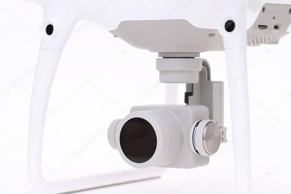 Close up of small camera on gimbal of drone on white background
