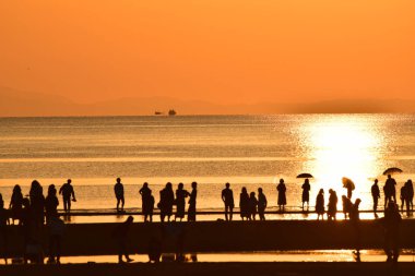 Birçok kişi bir deniz plajda silüeti. yansıma bir plajda