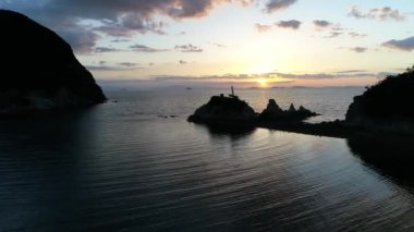 Önceden günbatımında sakin okyanus uçan drone havadan görünümden. Güzel bir akşam gökyüzü ile sakin deniz suya yansıyan