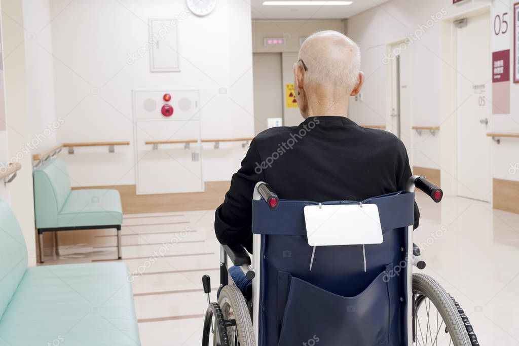 Back view of senior or elderly man sitting on wheelchair, consultation image.