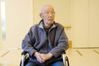 bakım evinde tekerlekli sandalye üzerinde oturan üst düzey veya yaşlı adam                            