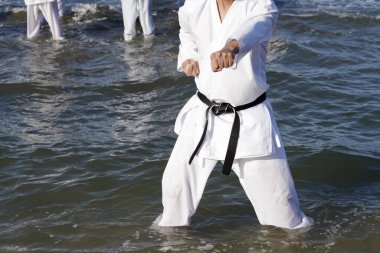 Japon karate dövüş sanatları eğitimi sahilde.