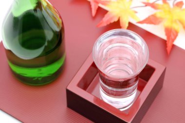 Tahta tepside, beyaz arka planda sake ile Japon ahşap kutu masu. 