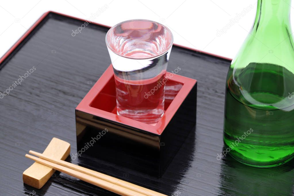 Japanese wooden box masu with sake on wooden tray, on white background  