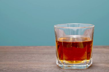 Eski ahşap bir masada cam bardak viski. 