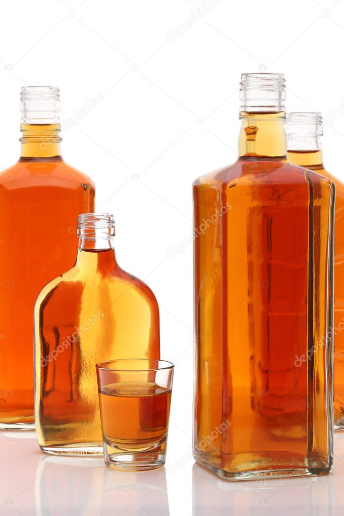 Glass cup and bottle of whiskey on white background  