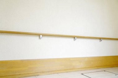 Beyaz duvarda parmaklıklar olan binada yürüme yolu.   