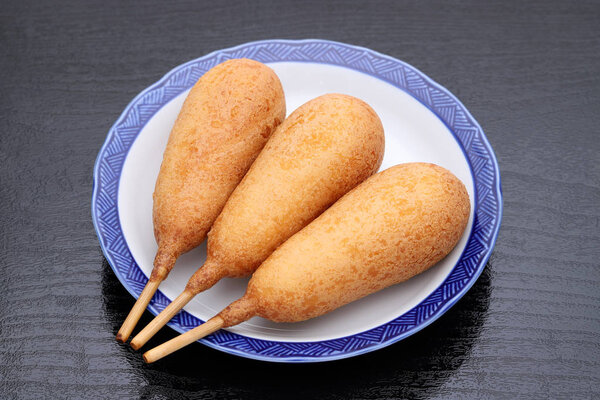 Корн-доги на тарелке. Эта еда называется американской собакой по всей Японии.
.