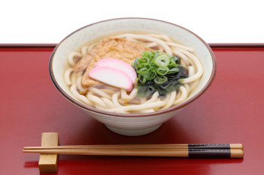 Japanese Kitune udon noodles in a ceramic bowl on wooden tray  clipart