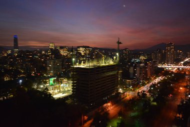 Şehir ışıkları ve gün batımı bulutları