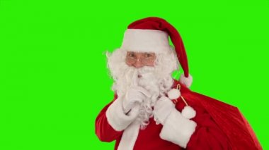 Çantasını taşıyan Noel Baba, kameraya bakar ve göz kırpar, Yeşil Ekran