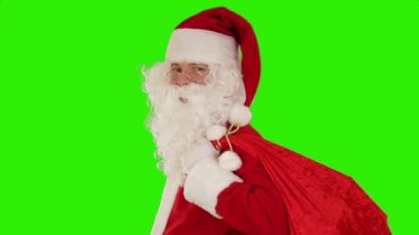 Çantasını taşıyan Noel Baba, kameraya bakar ve öper ve el sallar, Yeşil Ekran