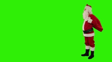 Noel Baba, yeşil ekranda yer açarak çanı sallıyor.