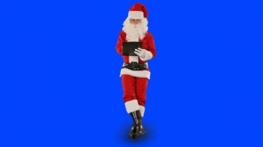 Noel Baba not alıyor ve bir şeyin üzerine oturuyor, Mavi Ekran Kromakey.