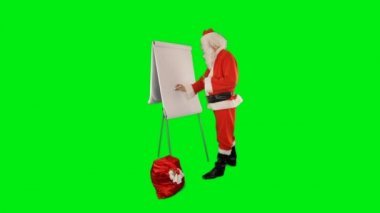 Bir çanta dolusu hediyeyle Noel Baba bir veri kartı çiziyor, Yeşil Ekran Chromakey.