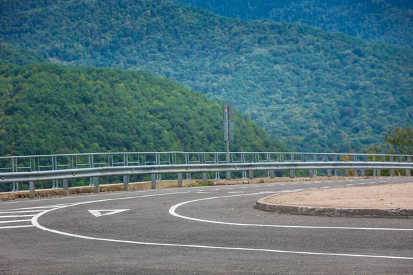 A view of a curved road. Driving a car on mountain road. Asphalt road in mountain. Empty road background