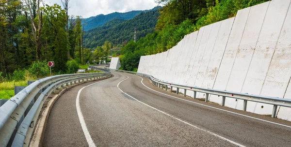 A view of a curved road. Driving a car on mountain road. Asphalt road in mountain. Empty road background