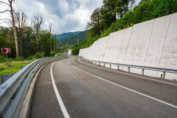 A view of a curved road. Driving a car on mountain road. Asphalt road in mountain. Empty road background