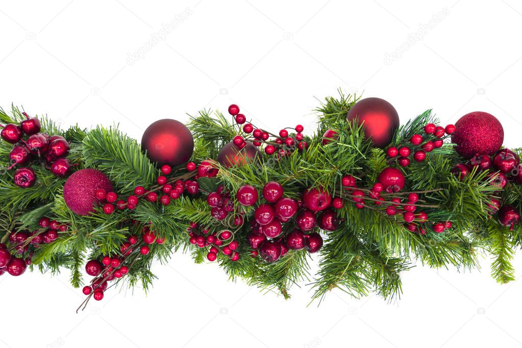 Christmas garland with red berries and baubles, isolated on white.