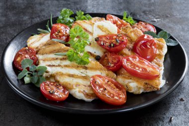 Hellim peyniri, kavrulmuş kiraz tomates ve otlar ile ızgara.