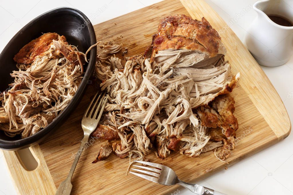 Pulled Pork Roast on Board with Forks and Jus